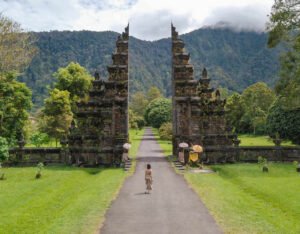 Tour package Bali family trips bali_0018_aerial-view-of-a-woman-in-front-of-iconic-handara-gate-on-a-cloudy-bright-day-i